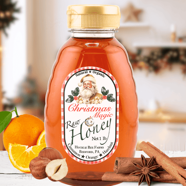 Christmas Magic Honey - Festive Holiday Flavor | Pure Delights in a 1 lb jar with cinnamon sticks, orange slices, and hazelnuts on a kitchen counter. Perfect seasonal condiment for tea or pancakes.