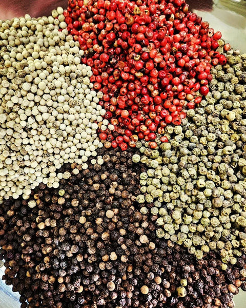 Four Peppercorn Blend featuring Tellicherry black, white, green, and pink peppercorns in a vibrant, aromatic mix for gourmet seasoning.