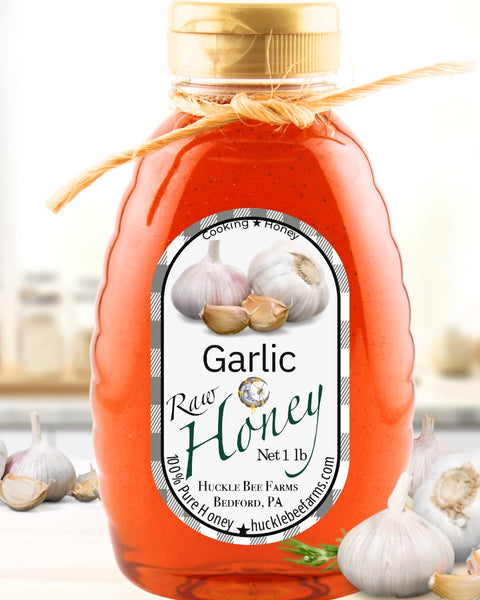 Garlic-infused raw honey in a 1 lb bottle, featuring a rich amber color and a rustic twine bow. Perfect for enhancing savory dishes with a sweet touch.
