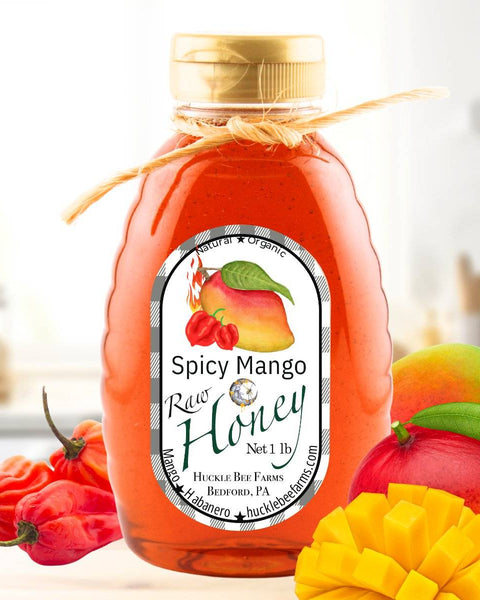 Spicy Mango Honey in a glass jar with a rustic twine bow, surrounded by fresh mangoes and habanero peppers, highlighting its sweet and fiery flavor.