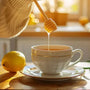 Woman preparing warm lemon water with honey for morning detox.