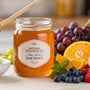 Jar of raw honey beside fresh fruit — small-batch, natural wellness