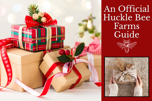 Huckle Bee Farms holiday honey gift box on rustic wooden table with pine cones, cinnamon sticks, and festive ribbon — small-batch infused honey bottles glowing in warm farmhouse light.