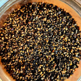 Close-up of coarse Applewood Smoked Black Pepper granules. Premium smoky seasoning ideal for enhancing grilled meats and savory dishes.