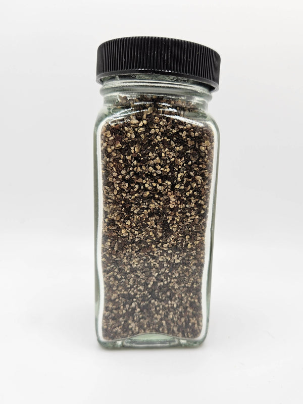 Chef's Grind Black Pepper in clear glass jar with black lid, showcasing coarse Tellicherry pepper perfect for meats, vegetables, and daily seasoning.