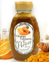 Golden jar of Huckle Bee Farms Orange Turmeric Honey with fresh orange slices and turmeric roots — immune boosting, anti-inflammatory honey blend.
