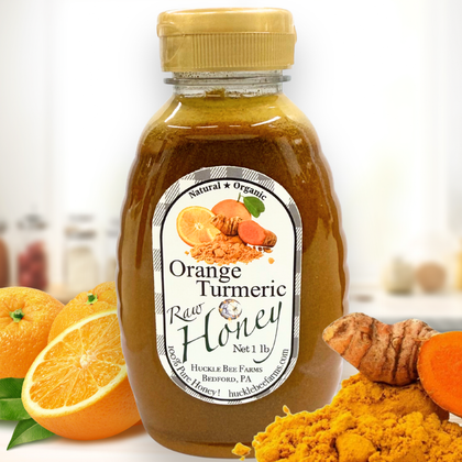 Golden jar of Huckle Bee Farms Orange Turmeric Honey with fresh orange slices and turmeric roots — immune boosting, anti-inflammatory honey blend.