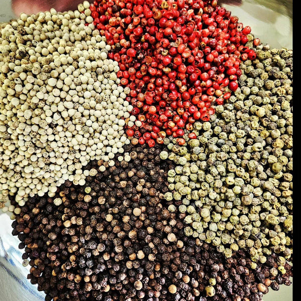 Four Peppercorn Blend featuring Tellicherry black, white, green, and pink peppercorns in a vibrant, aromatic mix for gourmet seasoning.