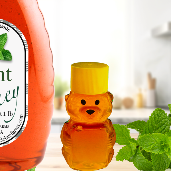 Mint Infused Honey in a decorative jar next to a bear-shaped honey bottle, surrounded by fresh mint leaves in a cozy kitchen setting.