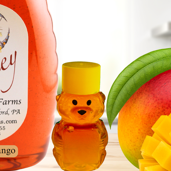 Close-up of Spicy Mango Honey bottle with a bear-shaped honey container and ripe mango, showcasing its natural ingredients and rich texture.