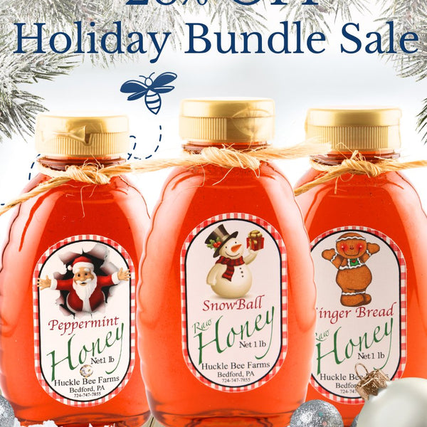 Three bottles of honey with festive labels on a snowy background, promoting a holiday bundle sale.