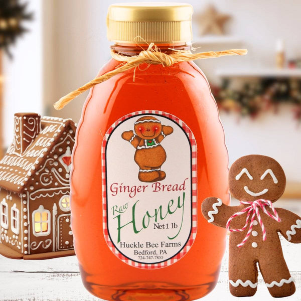 Bottle of gingerbread raw honey with a gingerbread man and house decoration in the background.