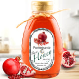 Rich amber pomegranate honey in a bottle, offering a fruity, antioxidant-rich infusion ideal for floral and herbal teas.