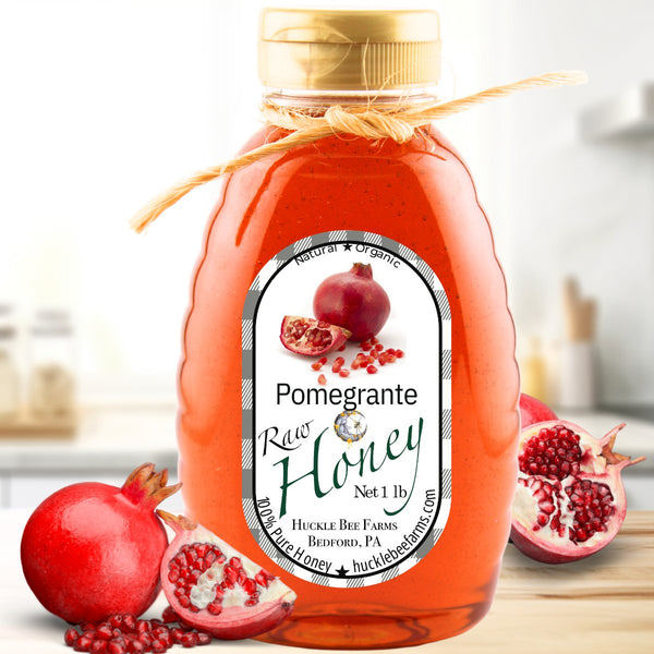Rich amber pomegranate honey in a bottle, offering a fruity, antioxidant-rich infusion ideal for floral and herbal teas.