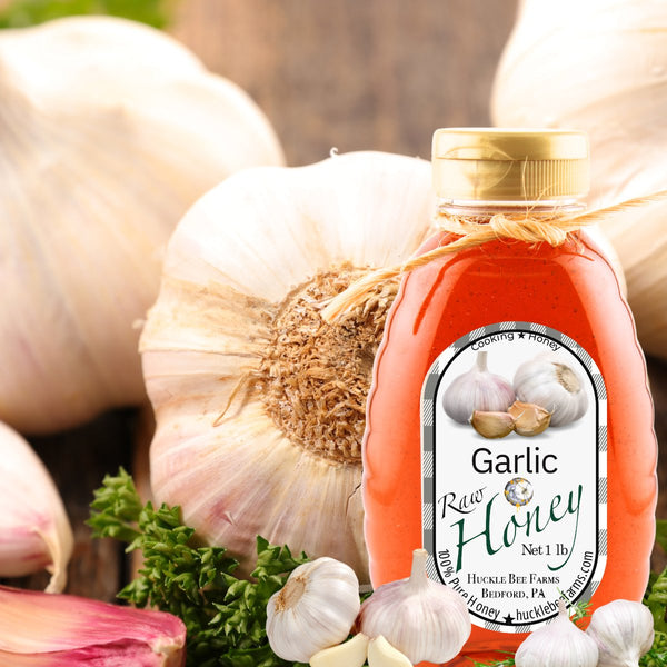 A bottle of garlic-infused raw honey set against fresh garlic bulbs and parsley, offering a gourmet blend for culinary enthusiasts.