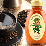 Irish Cream Honey from Huckle Bee Farms LLC in a 1 lb bottle with a leprechaun label. A rich blend of Irish cream and honey, perfect for coffee and desserts.