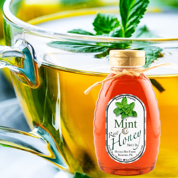 Mint Infused Honey bottle placed beside a cup of mint tea, highlighting its refreshing flavor and natural sweetness for beverages and recipes.