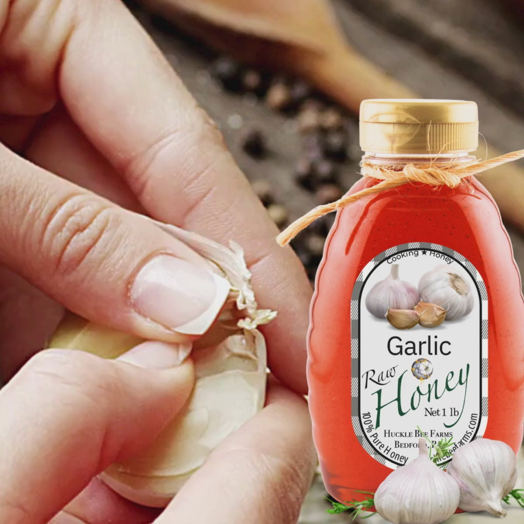 Garlic honey in a 1 lb bottle beside freshly peeled garlic cloves, ideal for cooking and adding a unique sweet-savory flavor to meals.