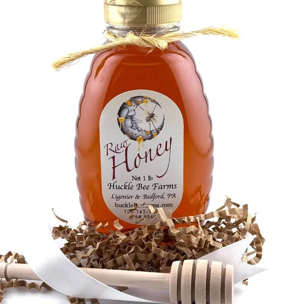 Raw honey bottle with decorative ribbon and dipper
