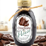 Chocolate Raw Honey 1 lb bottle from Huckle Bee Farms LLC, part of the S'more Bundle – Chocolate Honey & Marshmallow Honey. Surrounded by chocolate pieces.