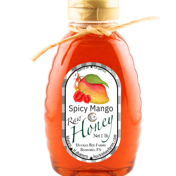 Spicy Mango Honey in a clear honey jar with a handcrafted label, emphasizing its raw, organic ingredients and rich golden color.