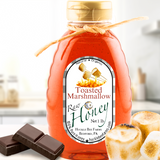 A golden swirl of toasted marshmallow honey glistening in warm light, evoking the sweet, cozy flavor of roasted marshmallows over a campfire.